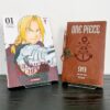 Presentoir manga posé sur une mangatheque expose le manga One Piece